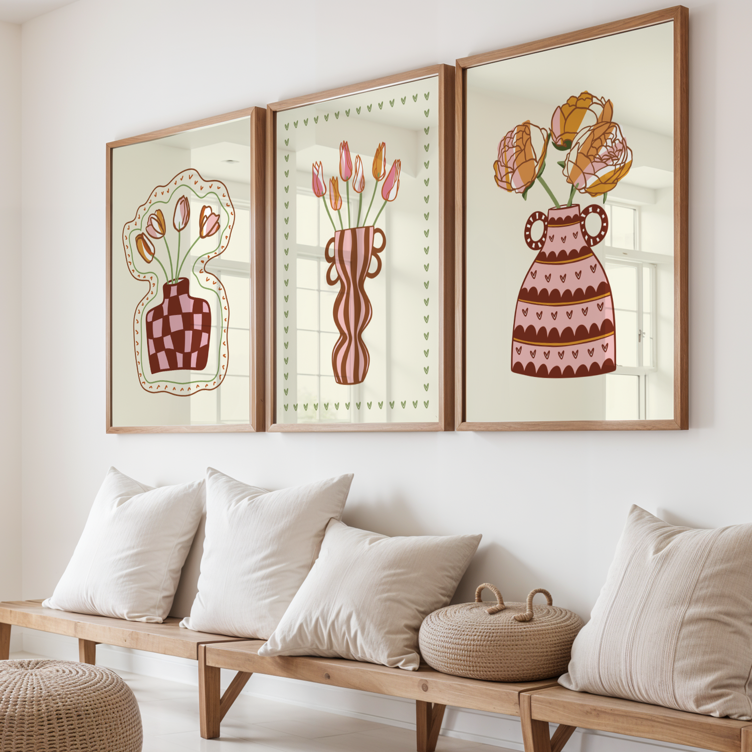 Three framed artworks of floral vases on a wall above a wooden bench with cushions.